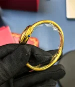 Close-up of the crown on the Cartier Baignoire WGBA0019 White Dial Gold Bracelet Women's Watch.