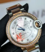 Close-up of the dial and diamond-set case on the Cartier Ballon Bleu De Two Tone Rose Gold and Steel 36MM Diamond Set watch.