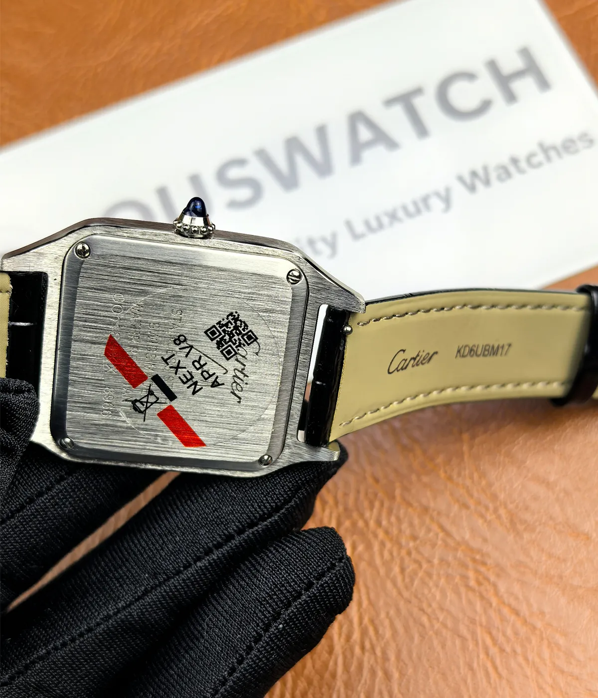 Close-up of the caseback on the Cartier WSSA0023 Santos Dumont Small Sapphire Crocodile Leather Watch Strap.