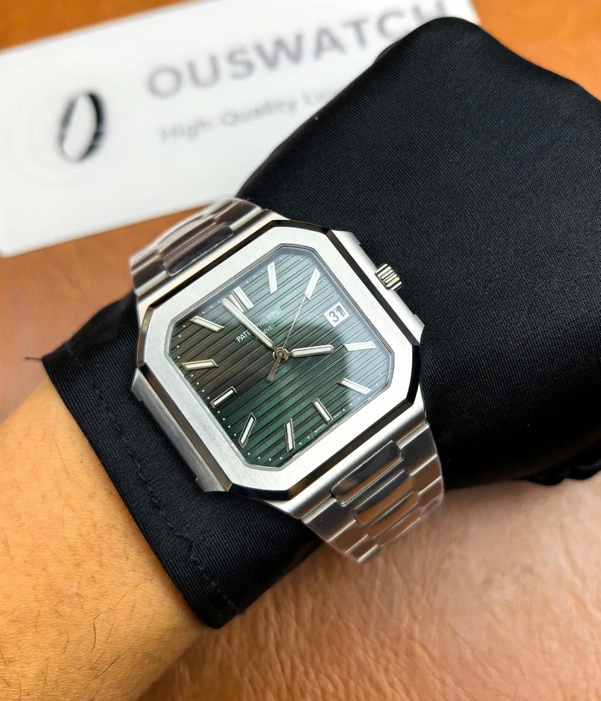 The Patek Philippe 5821/1A-001 men's watch with a green dial and steel strap being worn on the wrist.