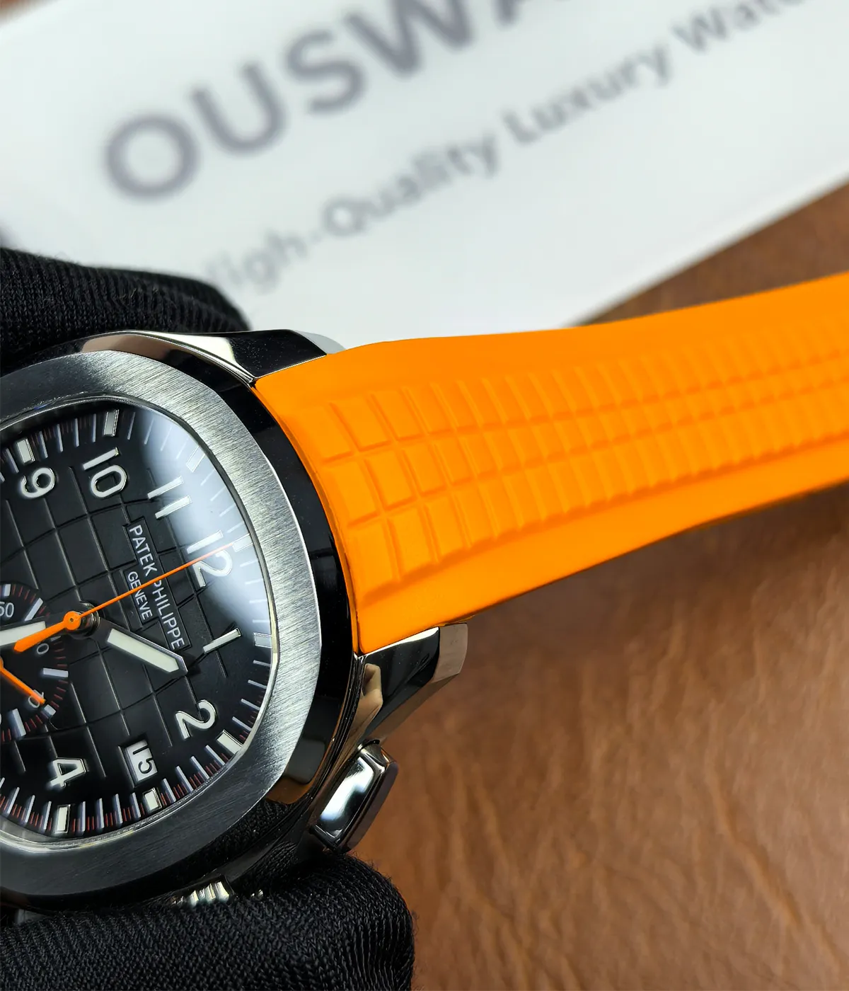 Close-up of the lugs on the Patek Philippe 5968A-001 Aquanaut with an orange strap and black dial.