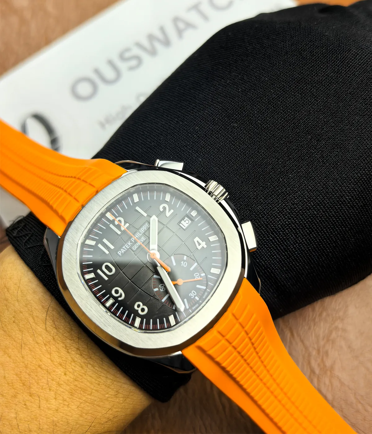 Patek Philippe 5968A-001 Aquanaut with an orange strap and black dial being worn on the wrist.