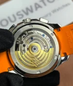 Close-up view of the movement inside the Patek Philippe 5968A-001 Aquanaut with an orange strap.