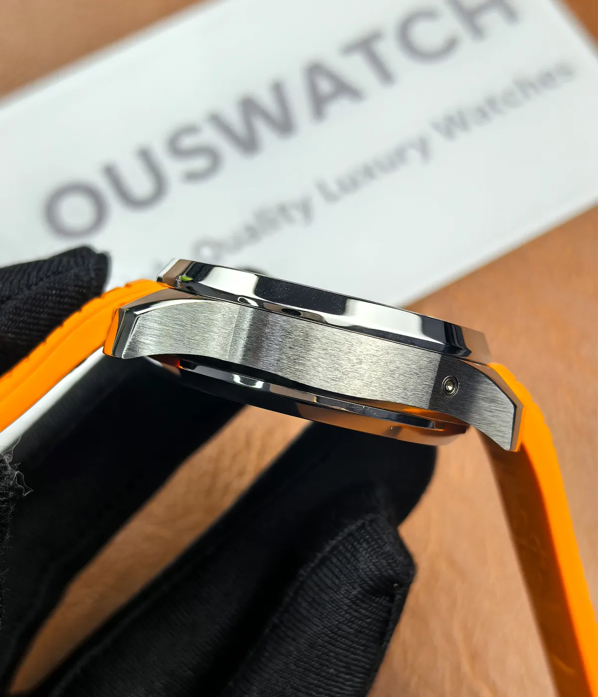 Side view of the Patek Philippe 5968A-001 Aquanaut with an orange strap, showcasing its satin finish.