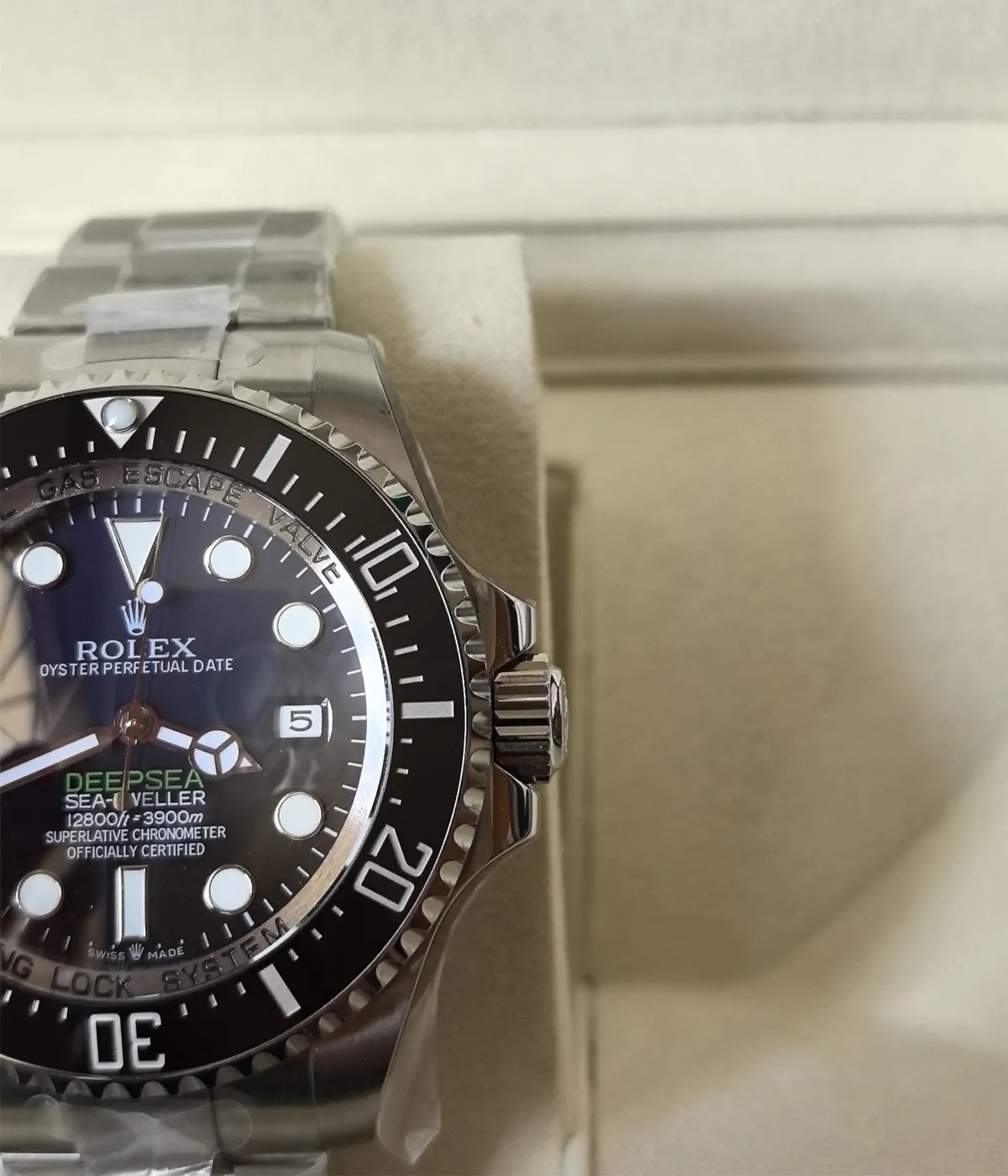 Close-up of the bezel and crown on the Rolex 44MM D-Blue Dial M136660-0005 with a black ceramic bezel and Oyster strap.