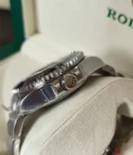 Close-up of the crown on the Rolex 44MM D-Blue Dial M136660-0005 with a black ceramic bezel and Oyster strap.