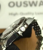 Close-up of the crown on the Rolex Bruce Wayne GMT Master II 126710GRNR 40mm men's watch.