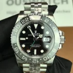 Front view of the Rolex Bruce Wayne GMT Master II 126710GRNR 40mm with a ceramic bezel, black dial, and green hands.
