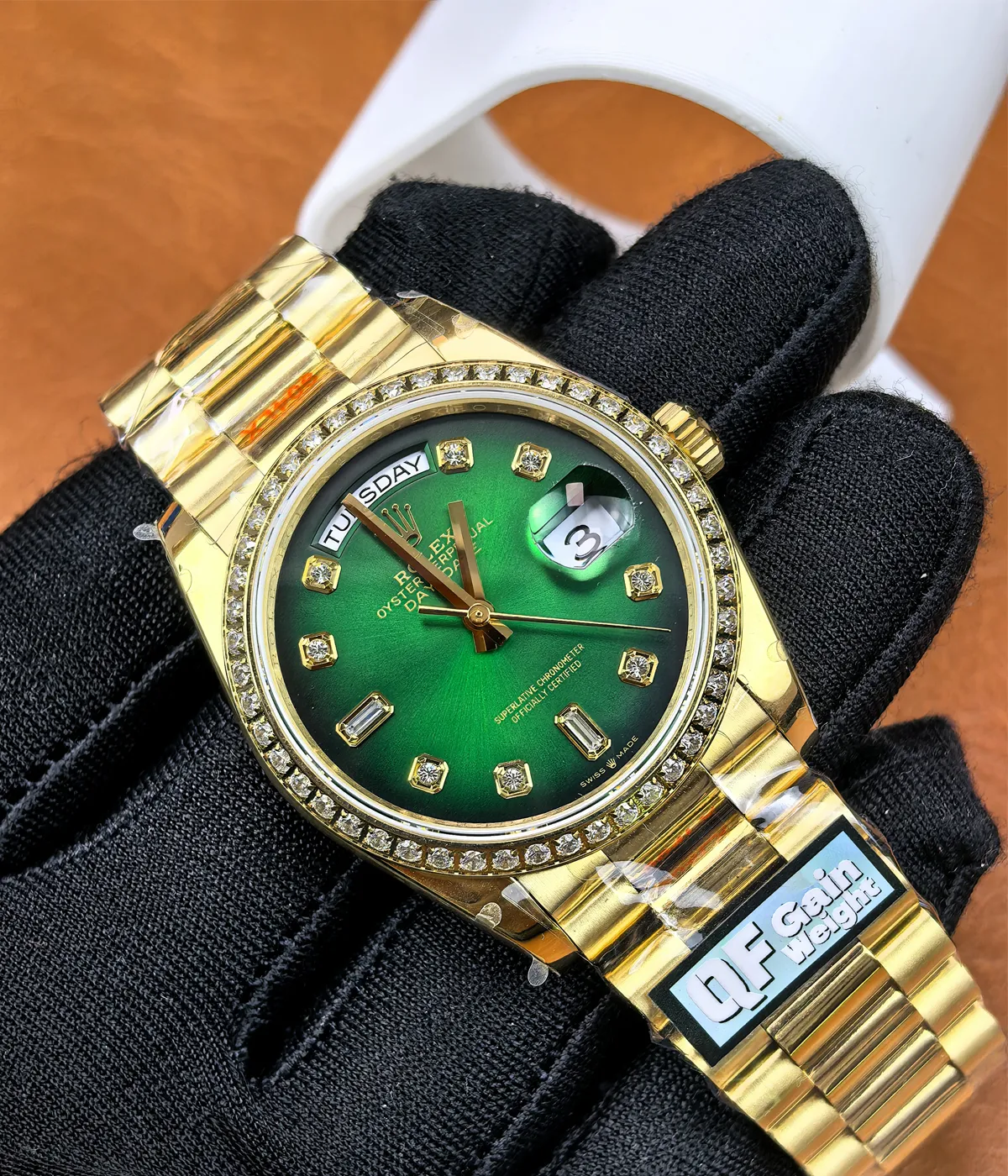 -45-degree angle view of the Rolex Day-Date M128348RBR-0035 with a green dial, gold Oyster strap, and diamond bezel for women.