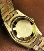 View of the caseback on the Rolex Day-Date M128348RBR-0035 with a green dial, gold Oyster strap, and diamond bezel for women.