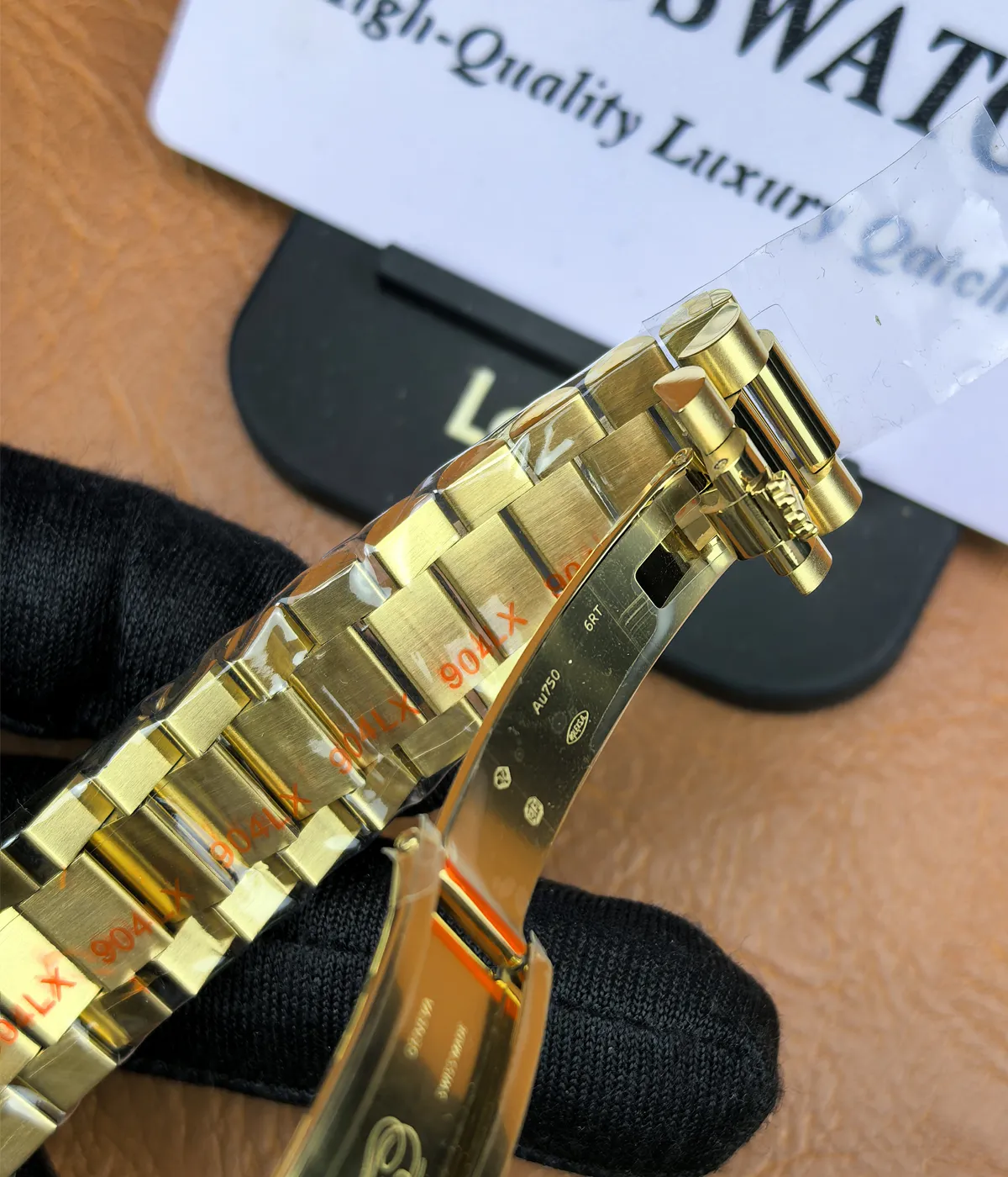 Close-up of the clasp on the Rolex Day-Date M128348RBR-0035 with a green dial, gold Oyster strap, and diamond bezel for women.