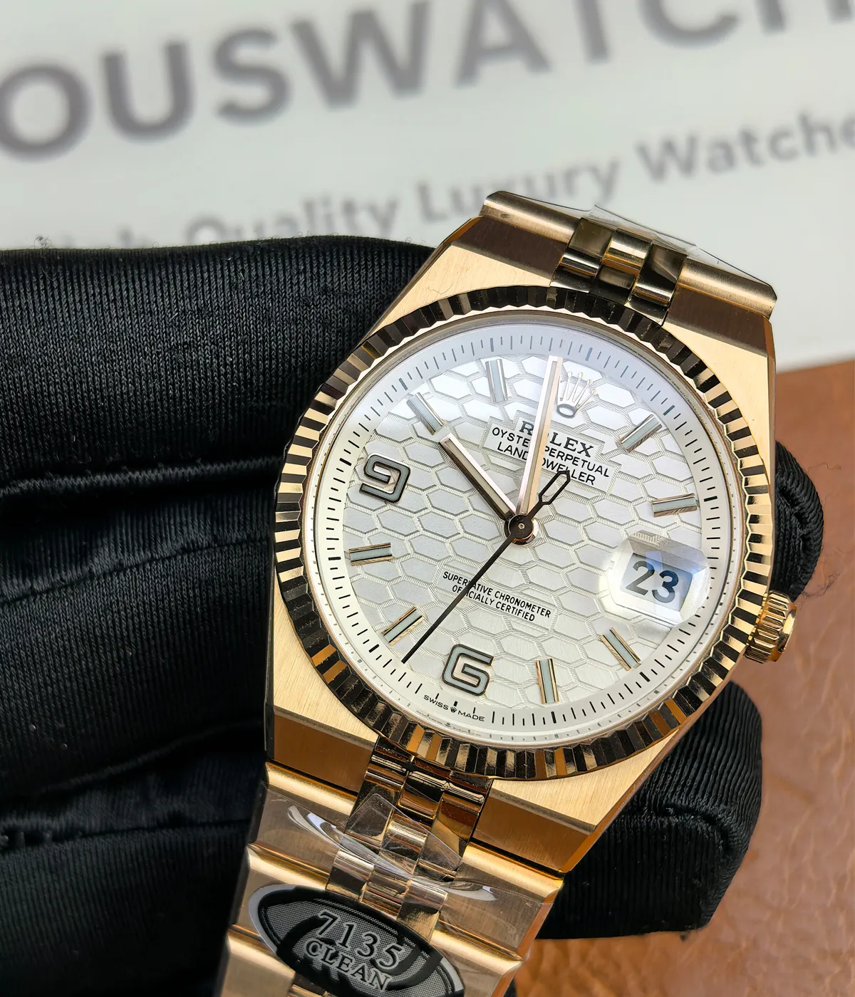 25-degree angle view of the Rolex Land-Dweller 127335-0001 with a rose gold case, triangular grooved bezel, and white honeycomb textured dial.