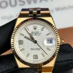 Front view of the Rolex Land-Dweller 127335-0001 with a rose gold case, triangular grooved bezel, and white honeycomb textured dial.