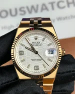 Front view of the Rolex Land-Dweller 127335-0001 with a rose gold case, triangular grooved bezel, and white honeycomb textured dial.