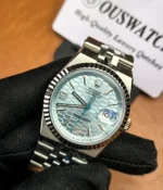 25-degree angle view of the Rolex Land-Dweller 127336-0001 with a platinum case, triangular grooved bezel, and ice blue honeycomb textured dial.