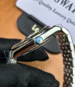 Close-up view of the crown on the Rolex Land-Dweller 127336-0001 with a platinum case and triangular grooved bezel.