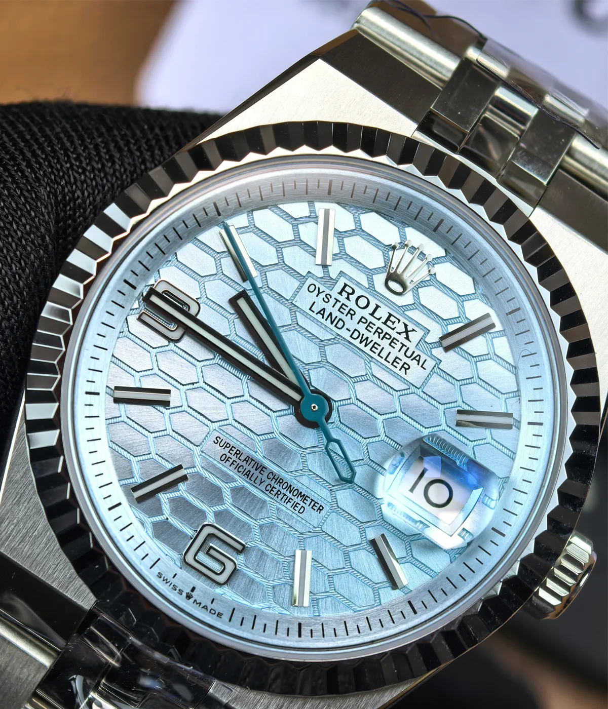 Detailed view of the dial and bezel on the Rolex Land-Dweller 127336-0001 with a platinum case and ice blue honeycomb textured dial.