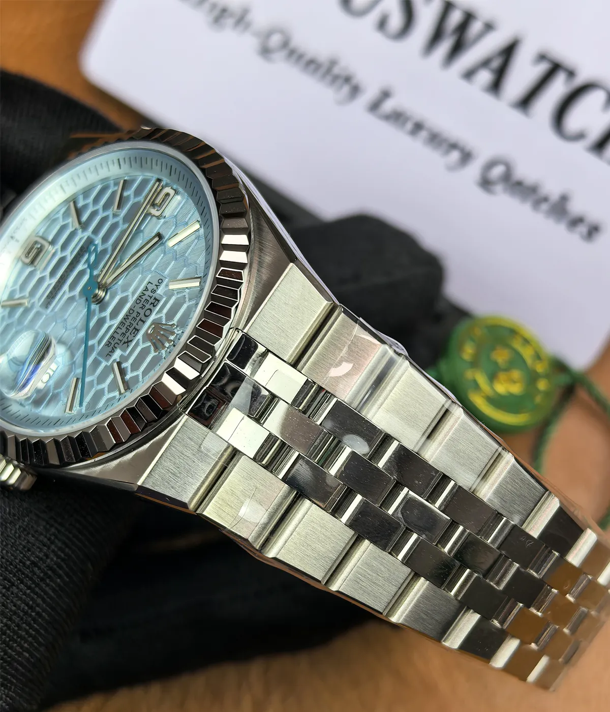 Close-up of the lugs on the Rolex Land-Dweller 127336-0001 with a platinum case, triangular grooved bezel, and ice blue honeycomb textured dial.