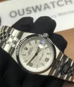 -45-degree angle view of the Rolex Land-Dweller 127334-0001 with a platinum case, triangular grooved bezel, and white honeycomb textured dial.