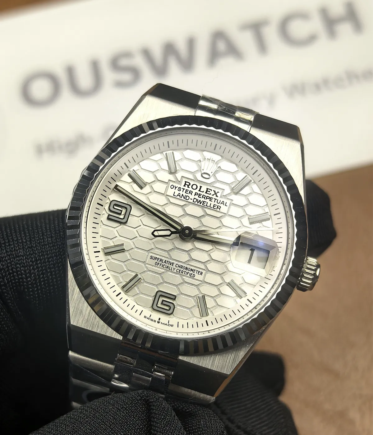 Front view showcasing the dial and bezel on the Rolex Land-Dweller 127336-0001 with a platinum case and white honeycomb textured dial.