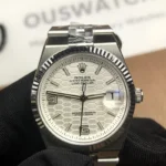 Front view of the Rolex Land-Dweller 127334-0001 with a platinum case, triangular grooved bezel, and white honeycomb textured dial.