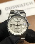 Front view of the Rolex Land-Dweller 127334-0001 with a platinum case, triangular grooved bezel, and white honeycomb textured dial.