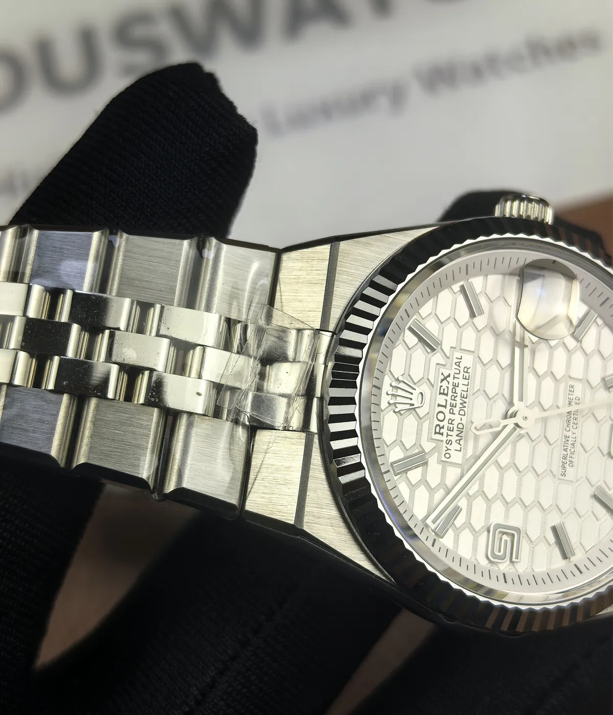 Close-up of the bracelet details on the Rolex Land-Dweller 127336-0001 with a platinum case and triangular grooved bezel.