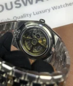 Close-up of the movement inside the Rolex Land-Dweller 127334-0001 with a platinum case and triangular grooved bezel.