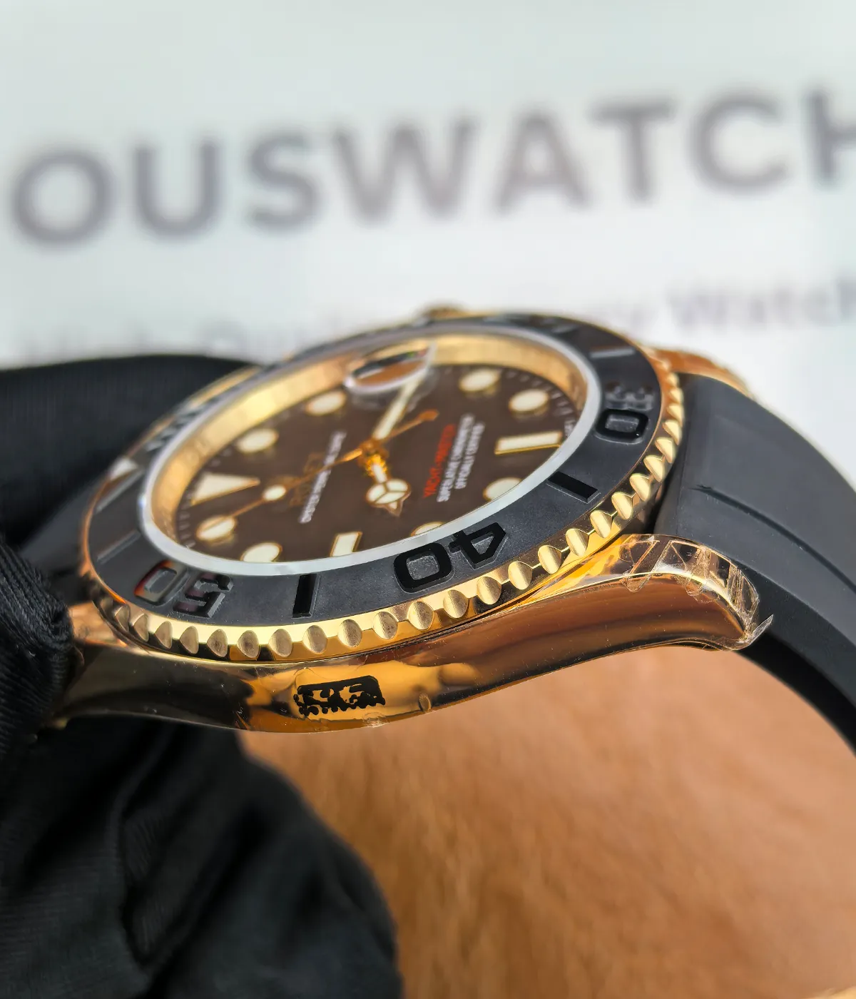 Side view showcasing the satin finish and rose gold case on the Rolex Rose Gold Yachtmaster 126655-0002 with a black dial and rubber strap.