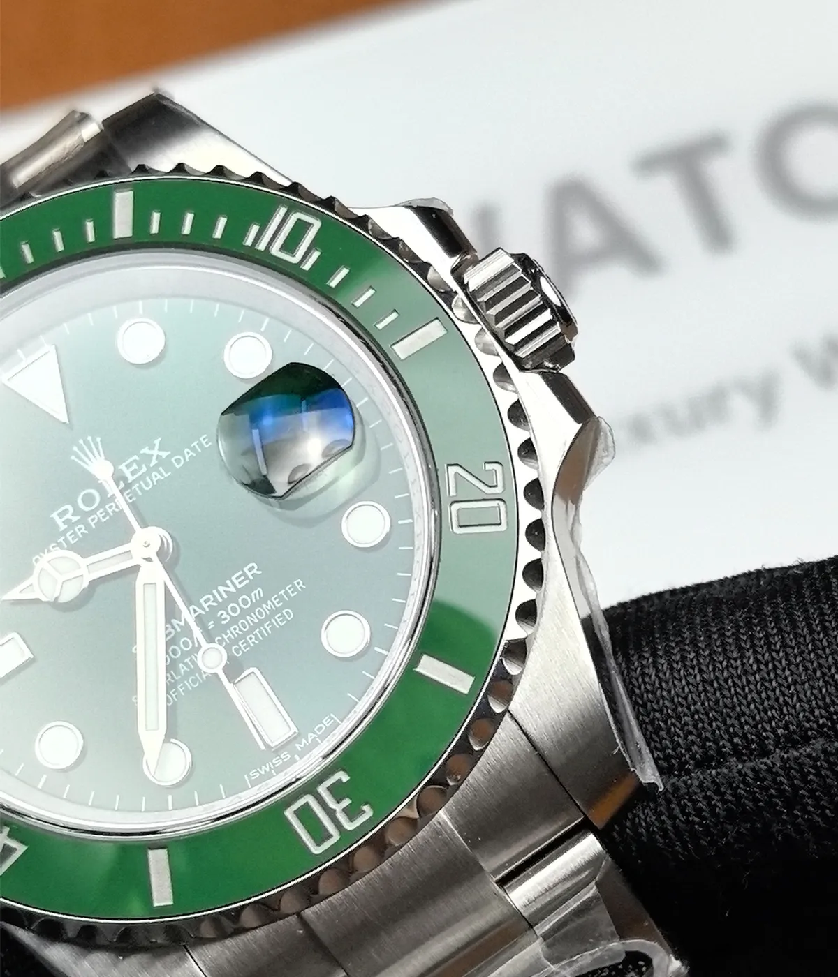 Close-up of the bezel and crown on the Rolex Submariner Date 116610LV-0002 with a 40MM green dial and Oystersteel case.