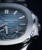 Close-up of the Patek Philippe Nautilus 5712-1A showing the blue luminous dial and steel case.