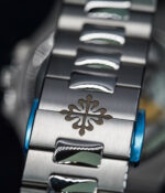 Bracelet display of the Patek Philippe Nautilus 5712-1A with a steel bracelet and blue luminous dial.